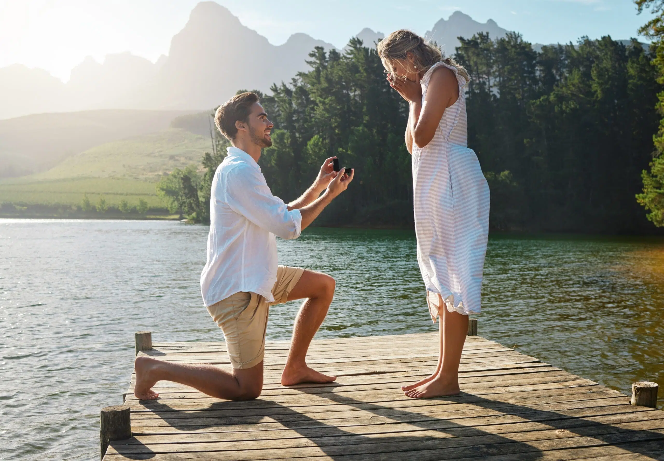 man proposing to woman at lake