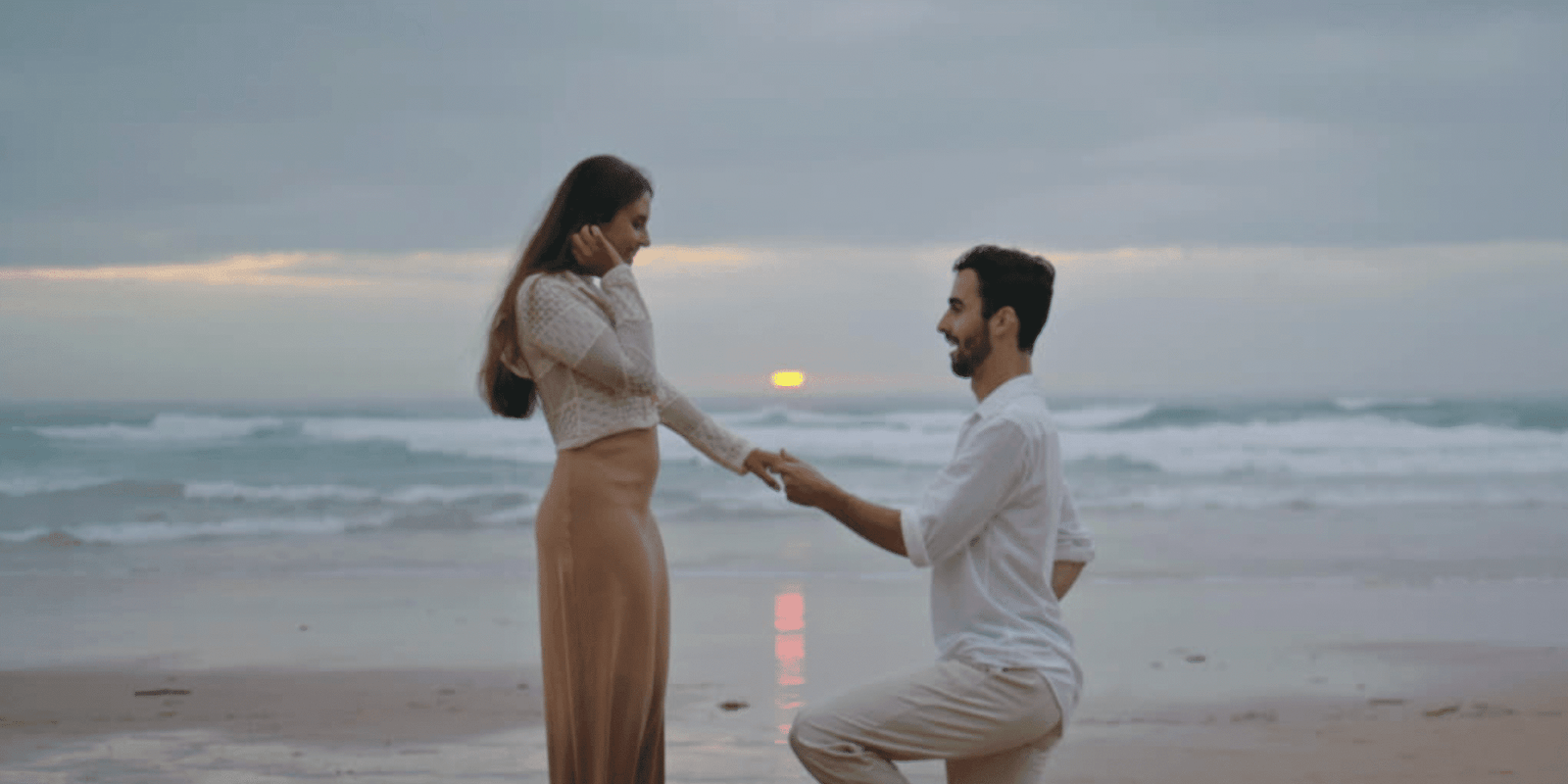 man proposing to woman at beach